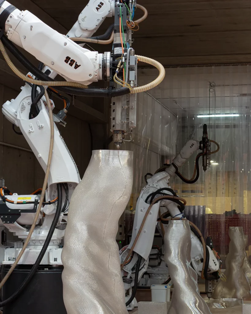 Robotic arm depositing material layer by layer.