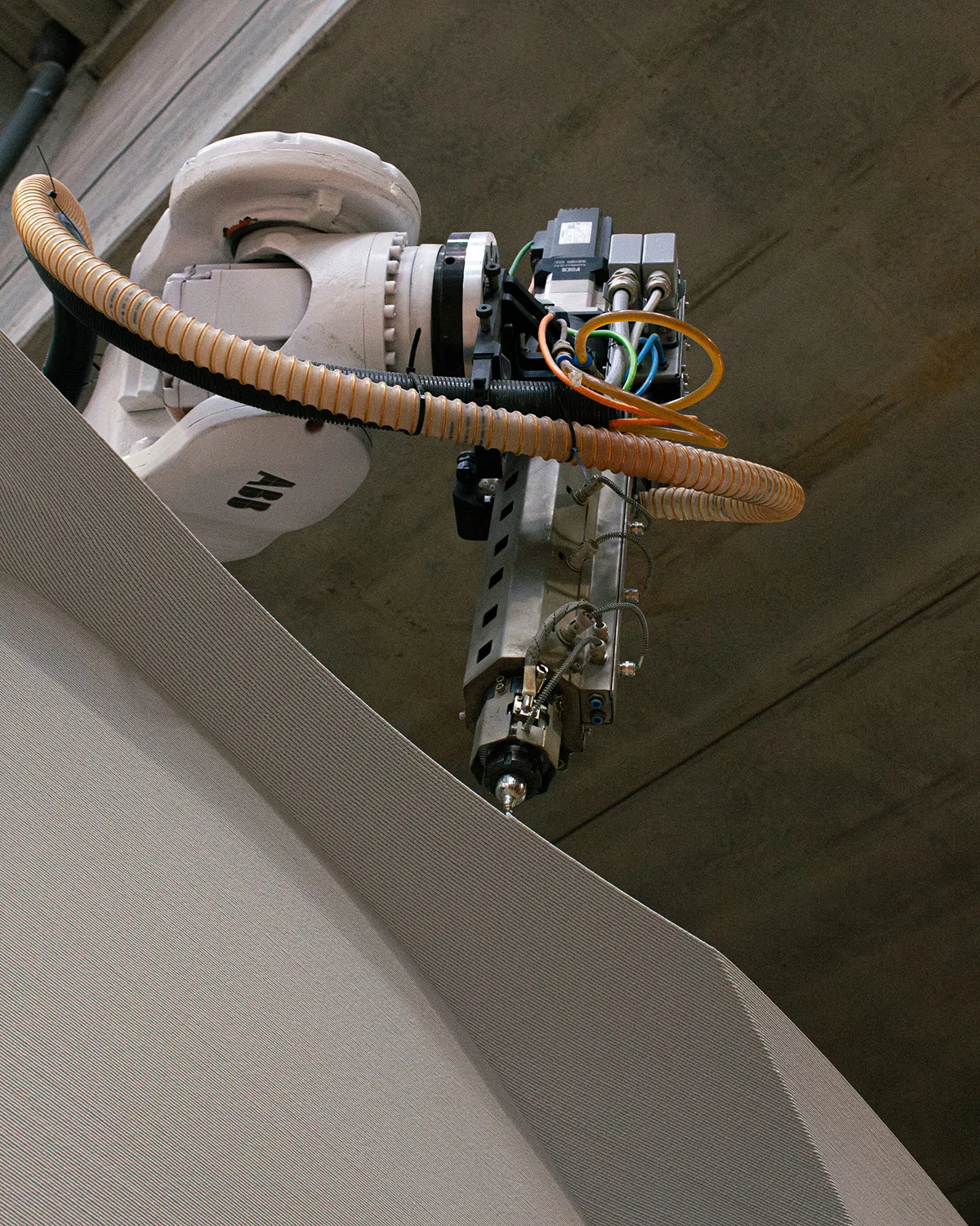 Robotic arm depositing material layer by layer.